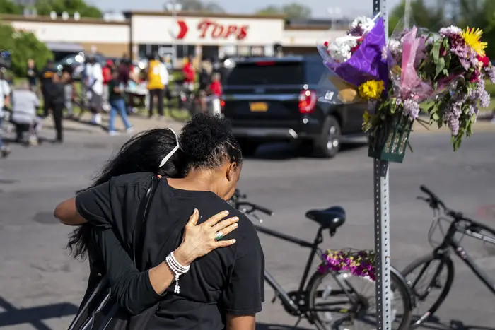 A photo of mourners at the site of a May mass shooting at the Tops Supermarket in Buffalo. The accused gunman is expected to plead guilty Monday